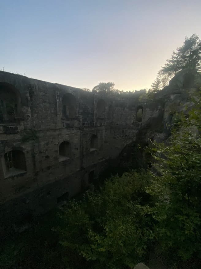 Hohe, verwitterte Festungsmauern im Abendlicht, von Bäumen umgeben